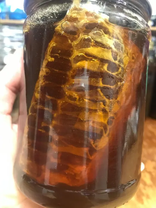 Closeup of honeycomb inside a jar of honey